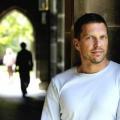 Julian Savulescu standing in a College archway with out of focus students in the background